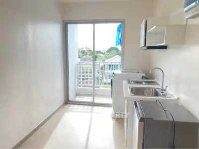 Bright kitchen with balcony view, featuring modern appliances and ample natural light.