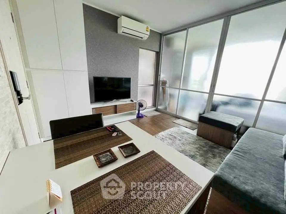 Modern living room with sleek design, featuring a TV, air conditioning, and stylish furniture.