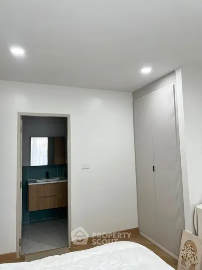 Modern bedroom with ensuite bathroom and sleek closet design.