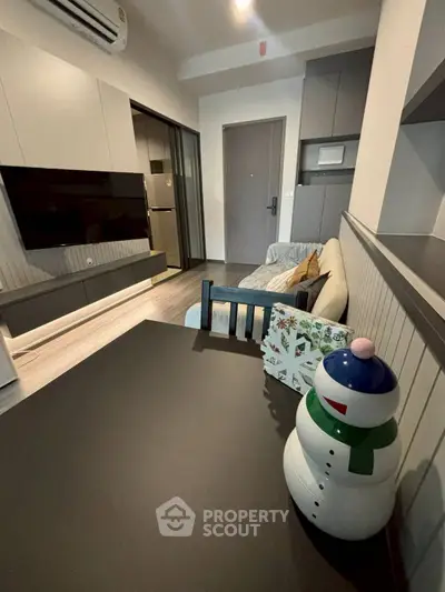 Modern living room with sleek furniture and festive decor in a cozy apartment setting.