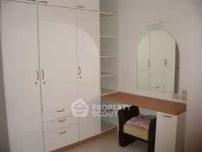Spacious bedroom with built-in wardrobe and vanity desk, perfect for modern living.