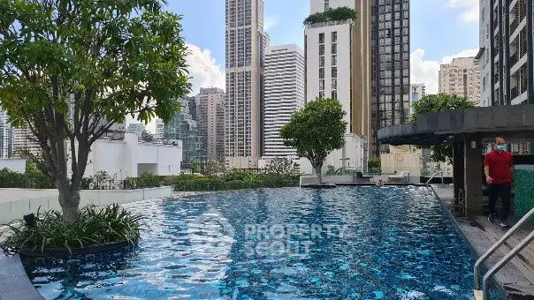Luxurious rooftop pool with stunning city skyline views and lush greenery.