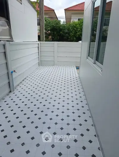 Charming outdoor balcony with tiled flooring and privacy fence, perfect for relaxation and outdoor activities.