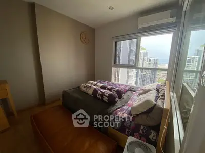 Cozy bedroom with city view, featuring modern decor and ample natural light.