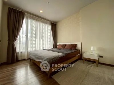 Spacious bedroom with large windows and modern decor in a high-rise apartment.