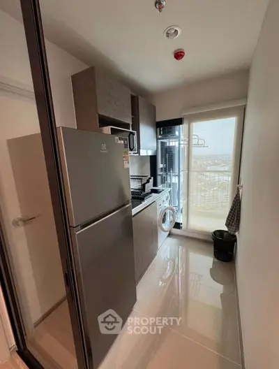 Modern compact kitchen with appliances and balcony view