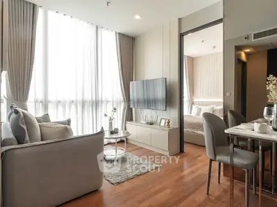 Modern living room with elegant decor and natural light, adjacent to a cozy bedroom.