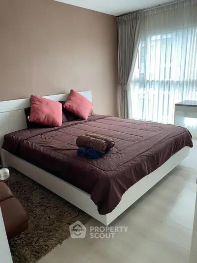 Modern bedroom with stylish decor and natural light, featuring a cozy bed and elegant curtains.