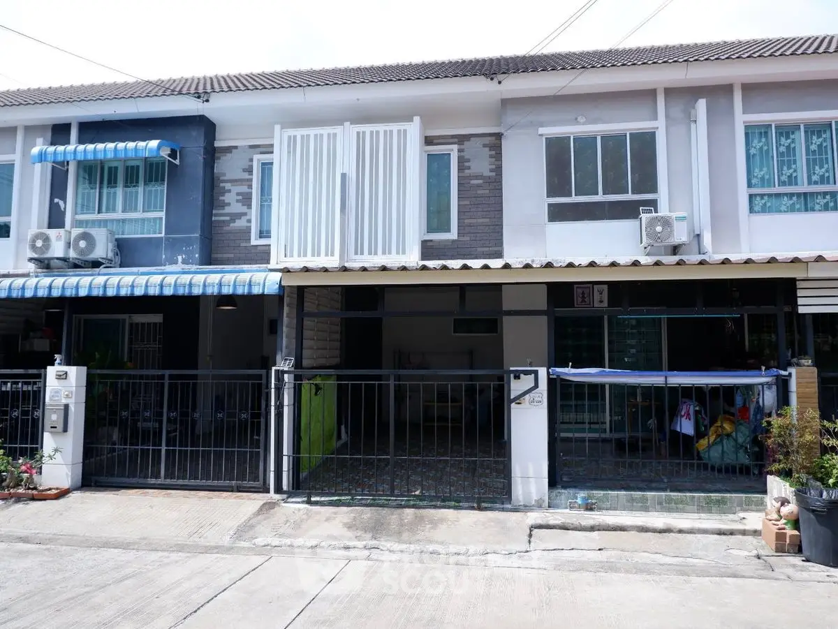 Charming townhouse with gated entrance and modern exterior design.