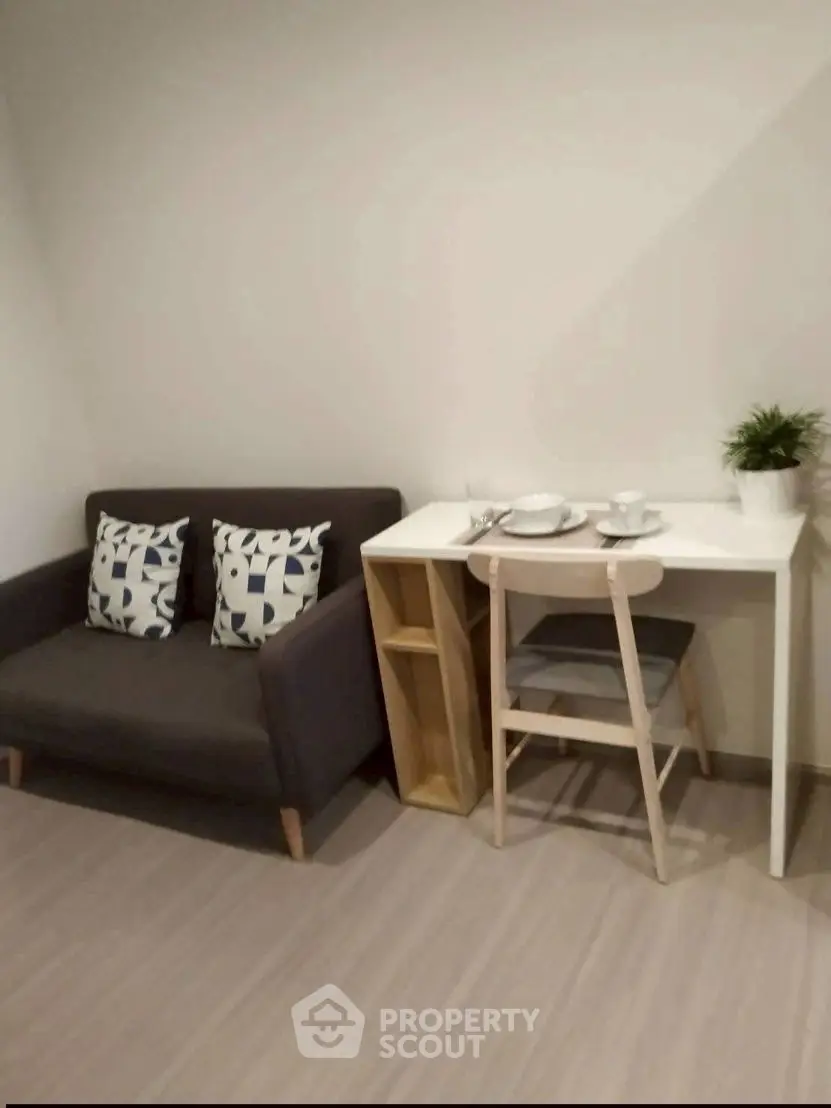 Cozy living area with modern sofa and dining table in compact apartment.