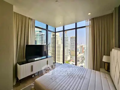 Luxurious bedroom with floor-to-ceiling windows offering stunning city views in a modern high-rise apartment.