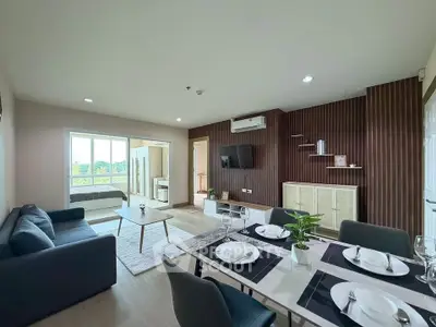 Modern open-plan living room with dining area and balcony view