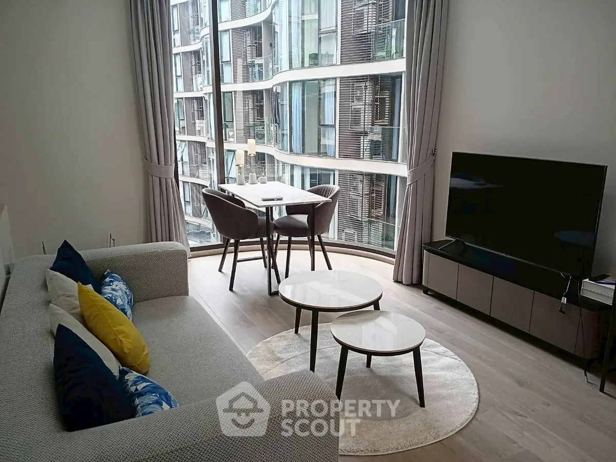 Modern living room with large windows and stylish furniture in urban apartment.