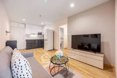 Modern living room with sleek furniture and open kitchen layout in a stylish apartment.