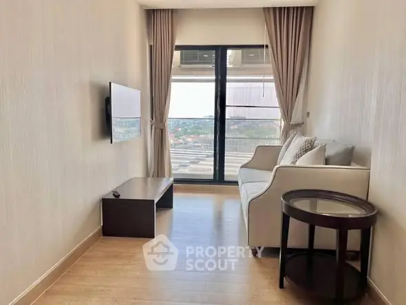 Modern living room with large window and city view, featuring a sleek sofa and wall-mounted TV.