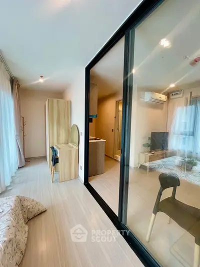 Modern apartment interior with glass partition, featuring a cozy living area and stylish decor.