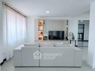Modern living room with sleek design, featuring a cozy sofa and stylish entertainment unit.