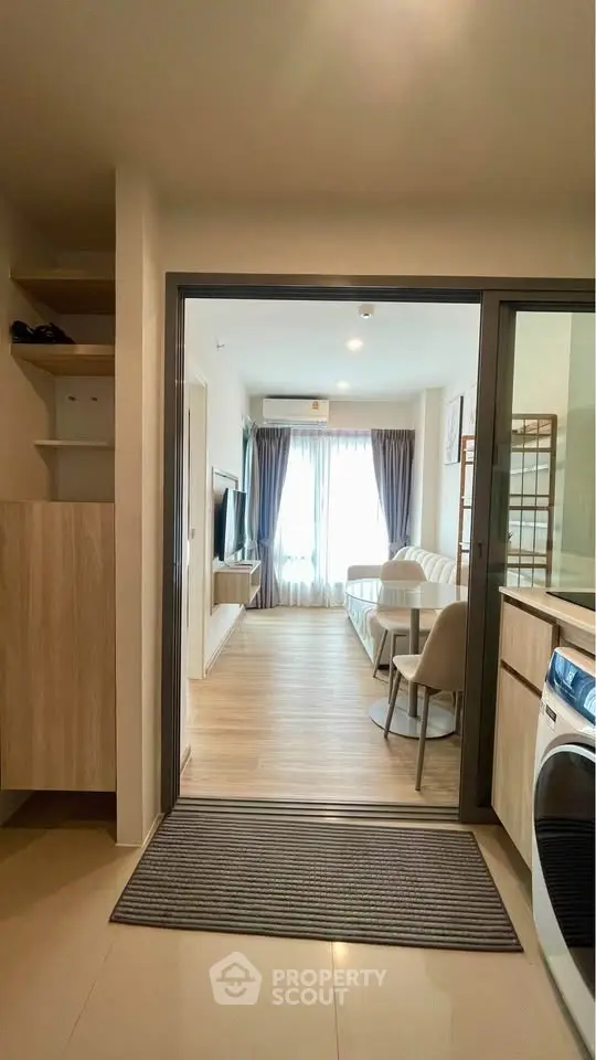 Modern apartment interior with open layout, featuring a cozy living room and kitchen area.