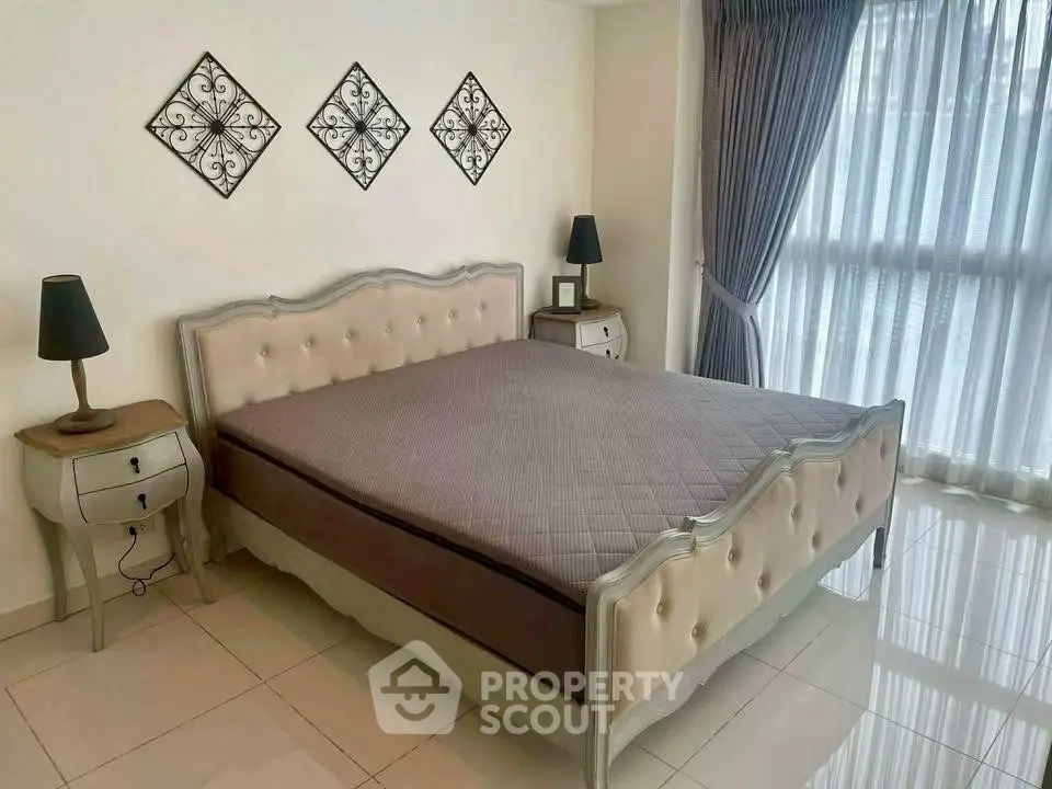 Elegant bedroom with stylish decor and large window for natural light.