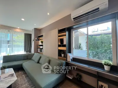 Modern living room with large windows and stylish green sofa