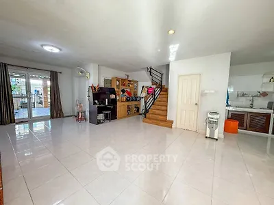 Spacious open-plan living area with modern staircase and ample natural light