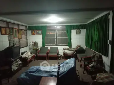 Cozy living room with vintage decor and green curtains, perfect for relaxation.