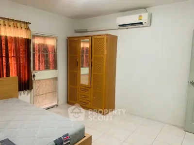 Spacious bedroom with air conditioning and wardrobe, ideal for comfortable living.