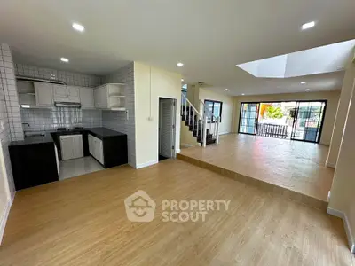 Spacious open-plan living area with modern kitchen and natural light