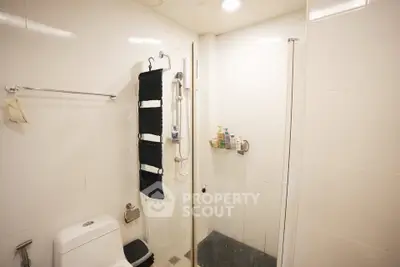 Modern bathroom with glass shower and sleek white tiles