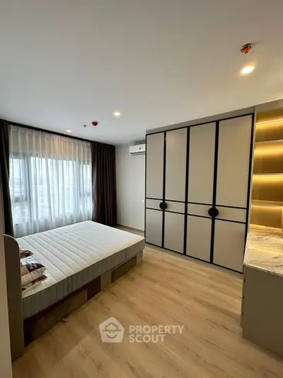 Modern bedroom with sleek wardrobe and large window in stylish apartment