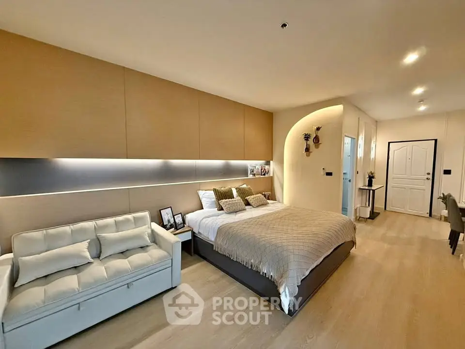 Spacious modern bedroom with cozy seating area and elegant lighting