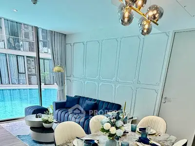 Luxurious living room with pool view, elegant decor, and modern furniture in a high-end apartment.