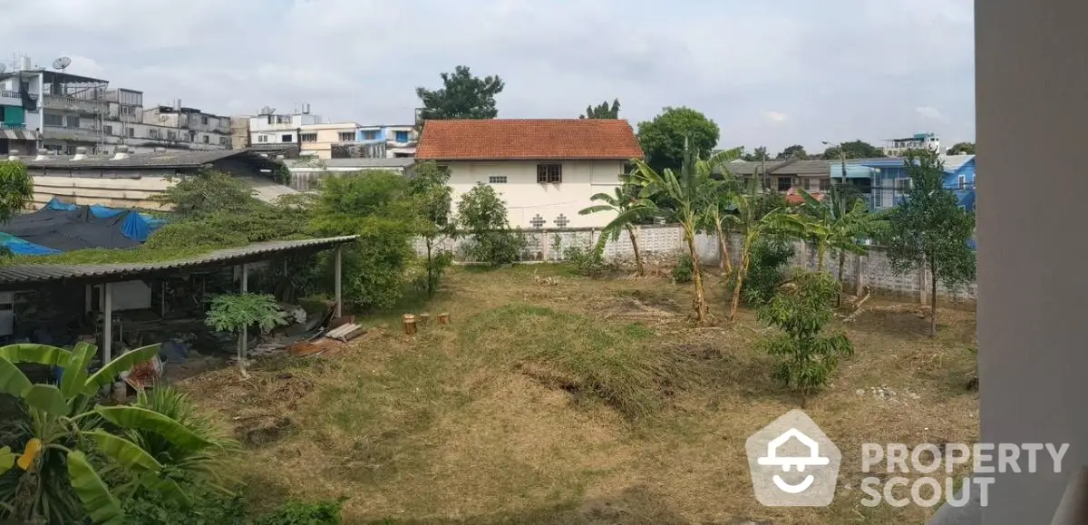 Spacious backyard with lush greenery and potential for landscaping in urban setting.