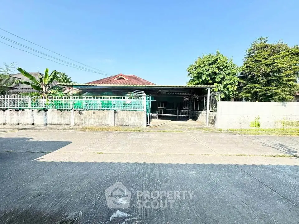 Spacious residential property with large driveway and lush greenery, perfect for family living.
