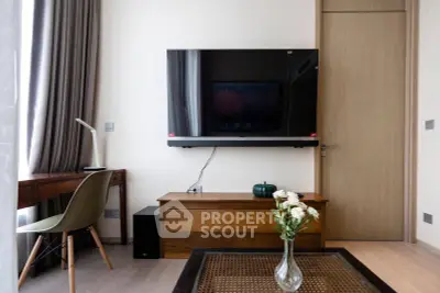 Modern living room with wall-mounted TV and stylish furniture in a cozy apartment.