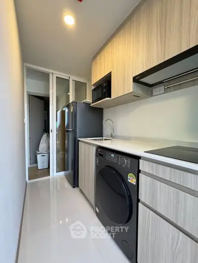 Modern kitchen with sleek appliances and closed layout in a stylish apartment.