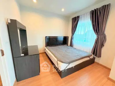 Modern bedroom with sleek furniture and large window for natural light.
