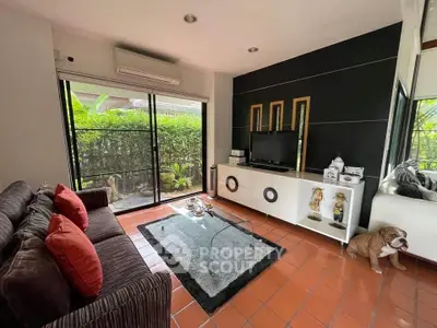 Charming living room with modern decor, large windows, and garden view, perfect for relaxation and entertainment.