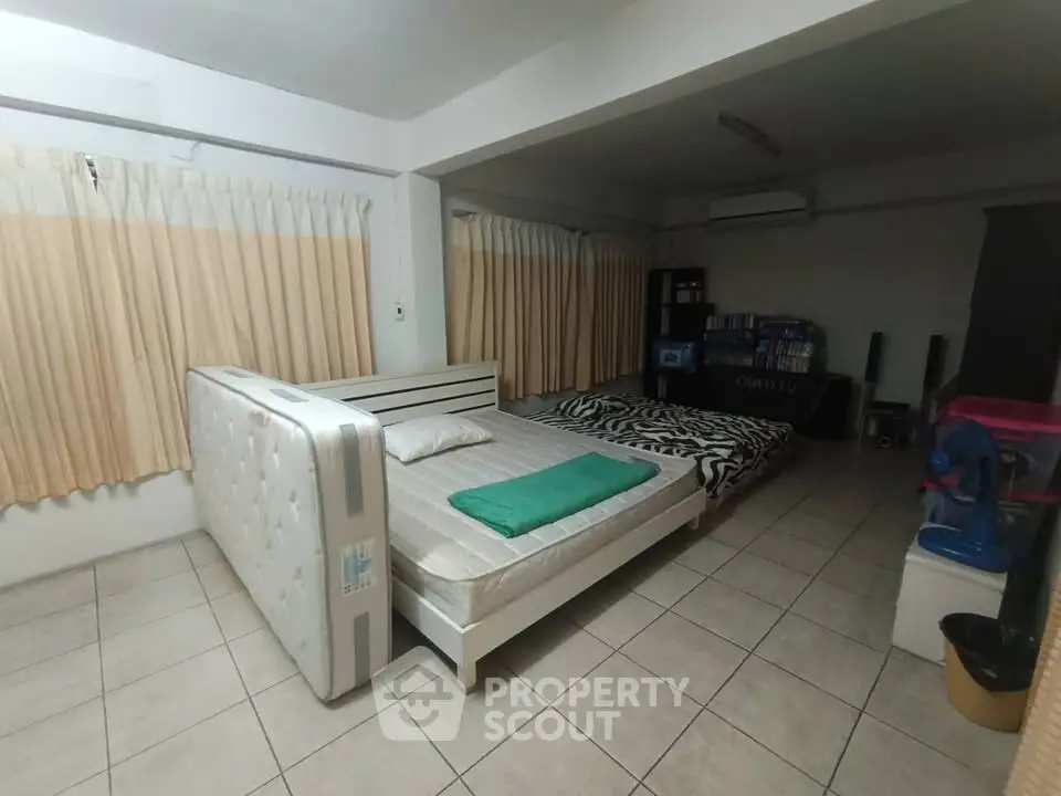 Spacious bedroom with tiled flooring and ample natural light, featuring a double bed and modern decor.