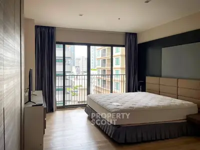 Spacious bedroom with large window and city view, featuring modern decor and natural light.