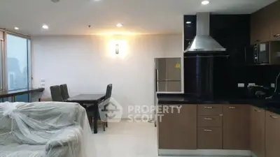 Modern open-layout kitchen and living area with city view, featuring sleek cabinetry and dining space.