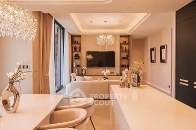 Luxurious modern living room with elegant decor and open layout, featuring a large TV and stylish lighting.
