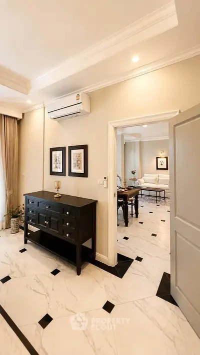 Elegant living room with marble flooring and stylish decor, featuring an open layout and modern air conditioning.