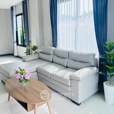 Elegant living room with plush white sofa and modern decor, perfect for relaxation and entertaining.