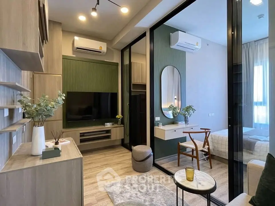 Modern living room with stylish decor and glass partition leading to cozy bedroom.