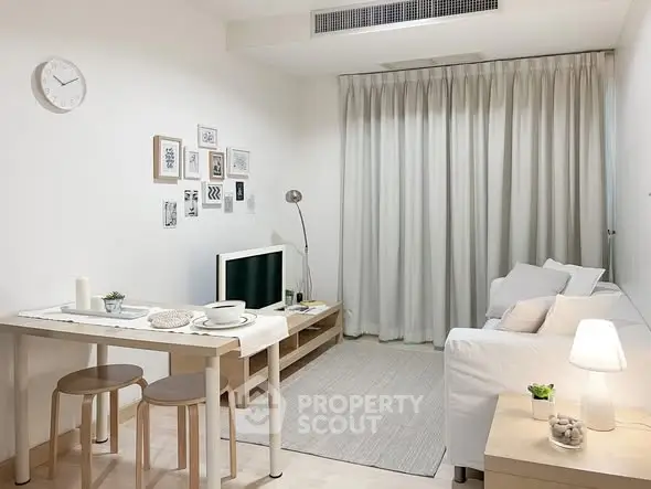 Modern living room with minimalist decor, featuring a cozy sofa, wall art, and a sleek TV stand.
