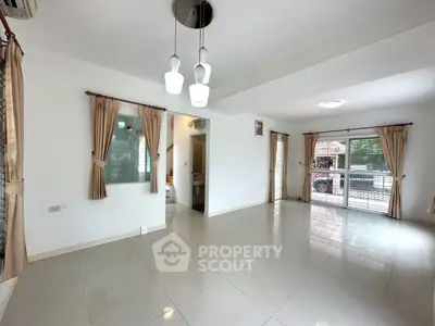 Spacious living room with large windows and modern lighting fixtures.