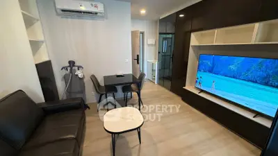 Modern living room with sleek furniture and large TV, perfect for relaxation.