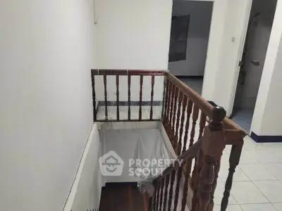 Charming interior staircase with wooden railing in a cozy home setting.