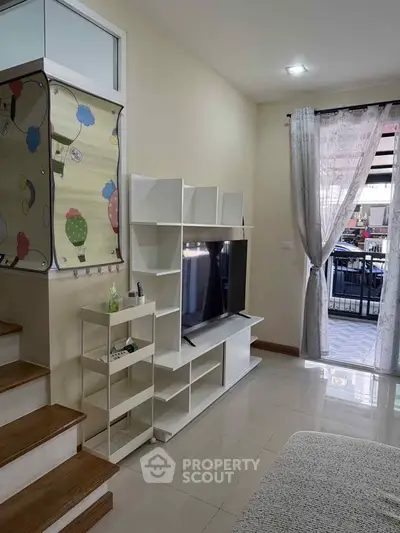 Modern living room with sleek TV unit and balcony access, perfect for urban living.